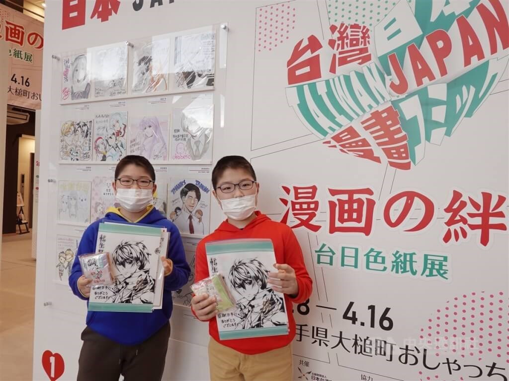 台湾漫画家の作品と周辺グッズを手にする子どもたち