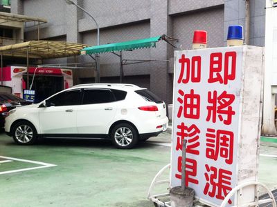 ガソリンスタンドの一角。看板には「もうすぐ値上げだ。給油するならお早めに」の文字が。