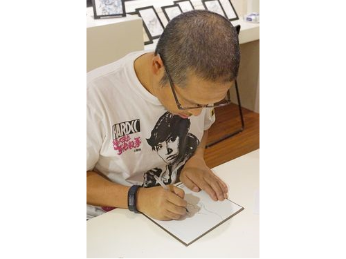台湾のファンに向けてイラストを描く寺田さん。絵を描くのには「筋力と集中力が大事」だという。
