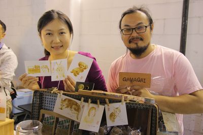 南部・高雄市でカフェ「GAVAGAI」を営む藍啓航さん（右）。共同経営者の秋謙さんは挿絵画家。この日はエスプレッソを原料にした絵の具でイラストを描く実演を行った。