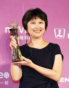 トロフィーを手に笑顔を見せる「オン ハピネス ロード」のソン・シンイン監督。アニメ作品賞はパン・スーユー(盤思妤)監督「霓虹」との同時受賞