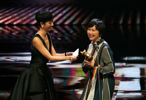 声優を務めた女優のグイ・ルンメイ（桂綸[金美]、左）からトロフィーを受け取るソン・シンイン監督