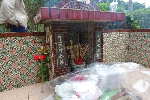 お参り後の土地の神様。この日は雨が降っていたが、50～60人の親戚が集まった。