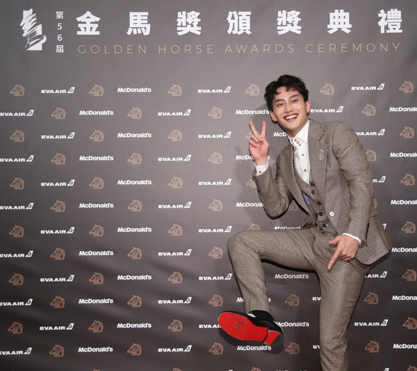 プレスルームで、ラッキーアイテムの「赤い靴底」を見せ、ピース姿で喜ぶファンディー・ファン