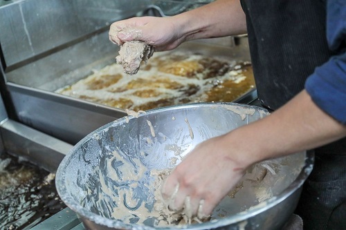 慣れた手つきで肉を油の中に投げ入れていく。