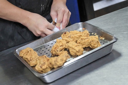 揚げた肉から骨が顔を出すようにぎゅっと押し込む。