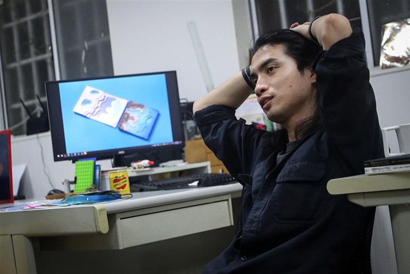 倉庫の一角にある自身のワーキングスペースに座る李政瀚さん(裴禛撮影)