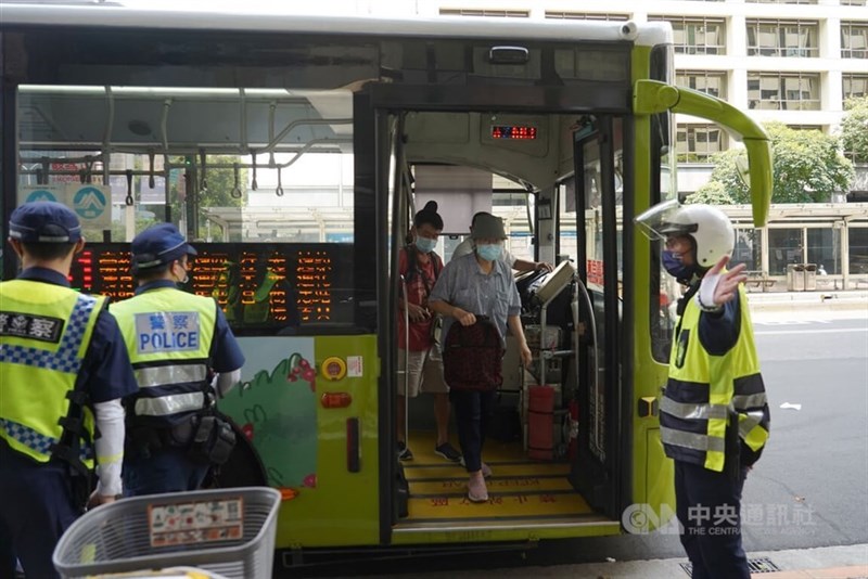 バスから降りる乗客を誘導する警察官＝台北市内、2022年7月25日撮影