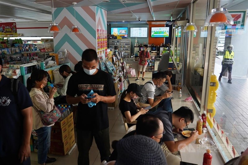 コンビニに退避した人々はスマホをいじって暇つぶししていた＝台北市中山区、2022年7月25日撮影