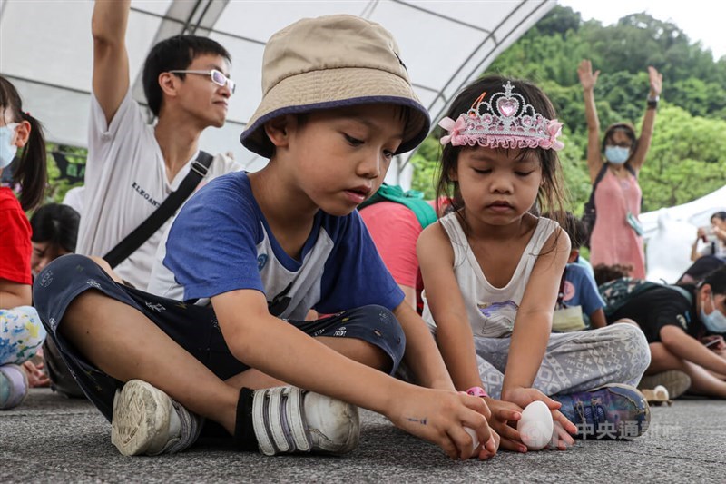 卵立てに挑戦する子供たち＝台北市立動物園で2023年6月22日、中央社記者鄭清元撮影