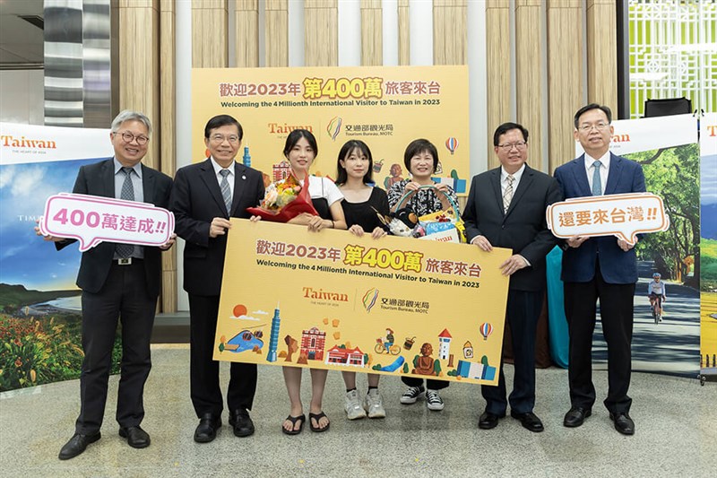 台北松山空港で今年400万人目の訪台客となる韓国人女性とその家族を出迎えた鄭文燦行政院副院長（右から2人目）、王国材交通部長（左から2人目）ら（観光局提供）