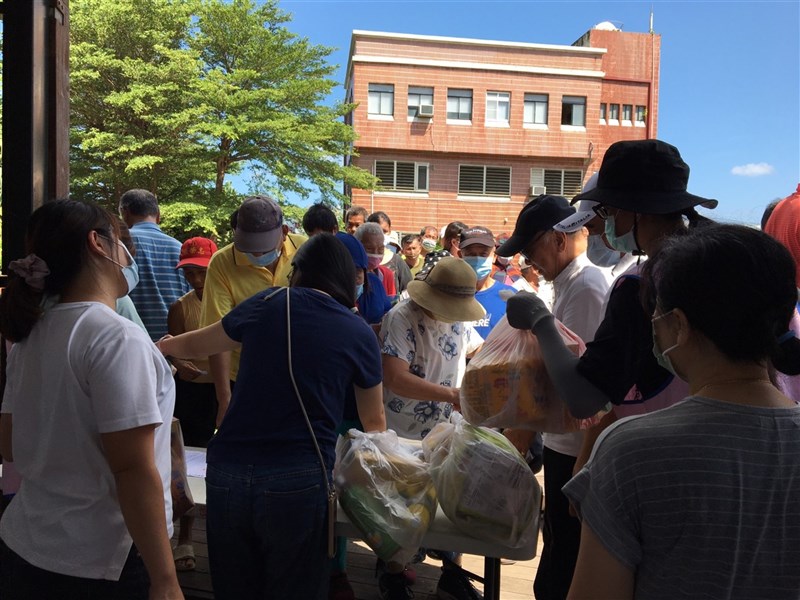 台風9号で中止になった伝統行事のために用意されたお供え物の無料配布に列を作る市民ら＝13日、恒春鎮公所提供