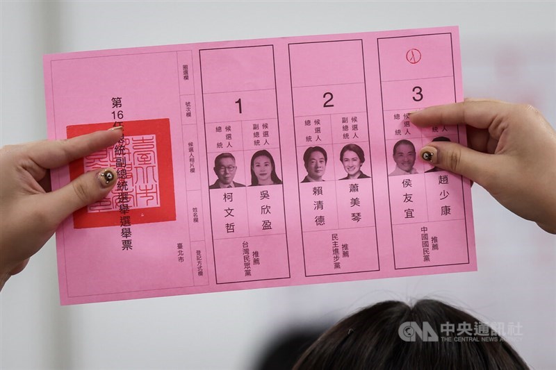 投票用紙を広げて公開する作業を行う投票所スタッフ。台湾の選挙の開票作業は、投票用紙の公開、読み上げ、集計の手順が踏まれる。有権者は票を入れる候補者の氏名の上の空欄にスタンプを押す＝台北市東区地下街投開票所で2024年1月13日、中央社記者裴禛撮影