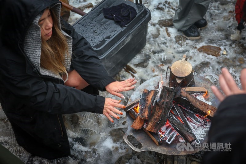 たき火で暖を取る人＝宜蘭・思源埡口で2024年1月23日、中央社記者王騰毅撮影