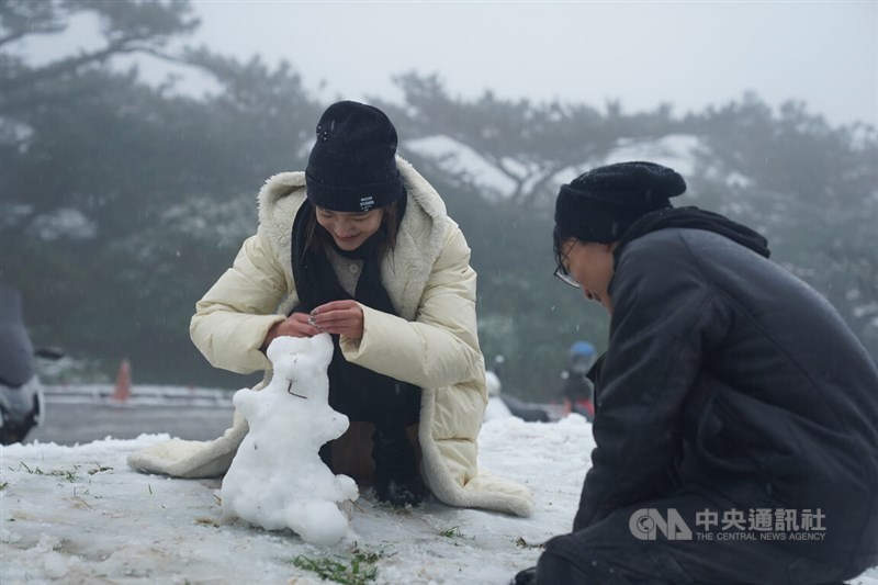 雪だるまを作る人＝大屯山で2024年1月23日、中央社記者徐肇昌撮影