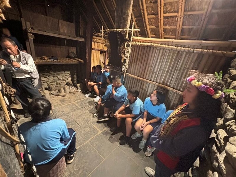 伝統家屋を再現した校舎の中で授業を受ける児童ら＝教育部提供