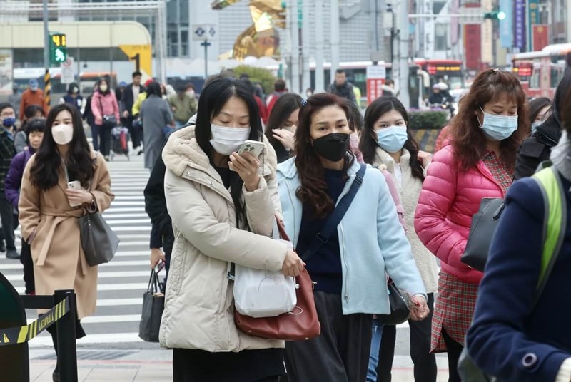 防寒コートやマスクなどで寒さをしのぐ人たち＝26日、台北で張皓安撮影