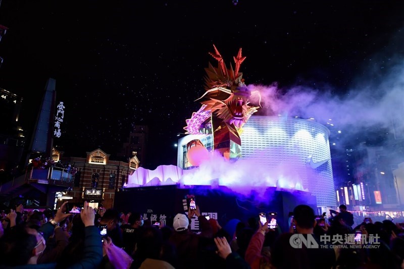 台北市観光伝播局主催の台北ランタンフェスティバル（台北灯節）の会場の一つとなる西門町には24日の元宵節当日、32万人以上が詰めかけた。MRT西門駅前に設置されたメイン作品「城現光竜」で光のショーが上演されると、多くの人がスマートフォンを向け、写真や動画を撮影していた＝2024年2月24日、中央社記者翁睿坤撮影