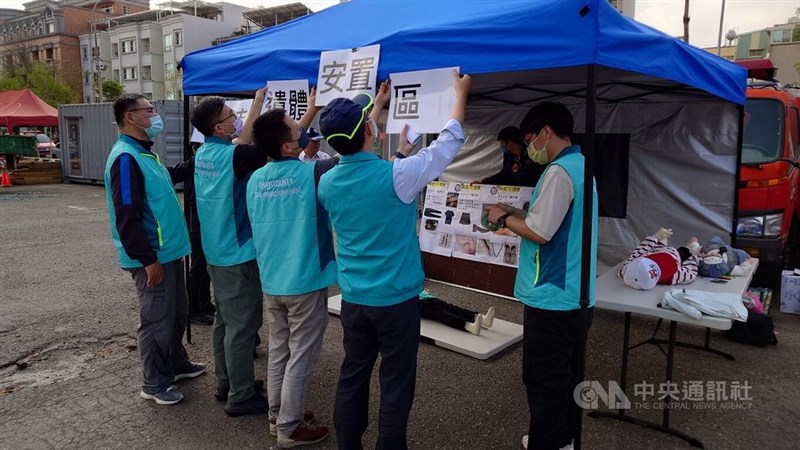 地震を想定した災害救助訓練で臨時の遺体安置所を設置する関係者＝3月25日、蔡智明撮影