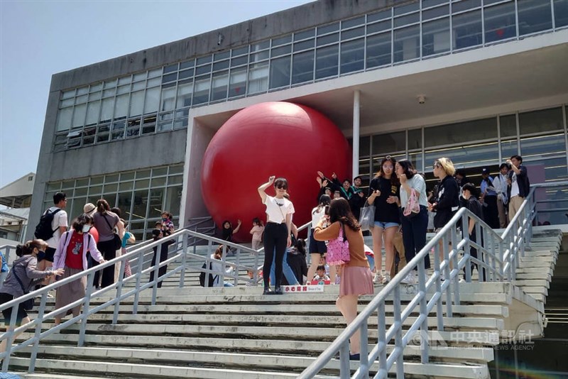 巨大な赤玉を背景に写真撮影を楽しむ人々＝1日、台南で楊思瑞撮影
