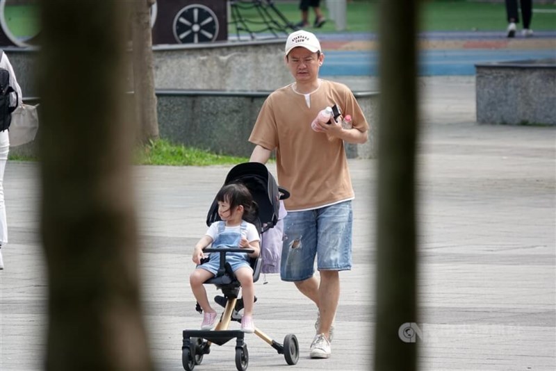 夏物を着て子供を連れて外出する男性＝15日、台北市で鄭傑文撮影
