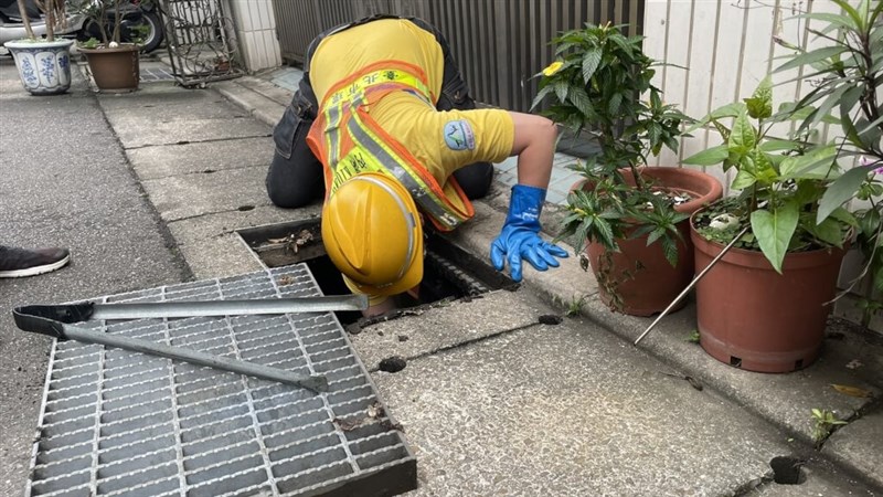 通報を受けて側溝で落とし物を探す清掃隊員（台北市環境保護局フェイスブックページより）