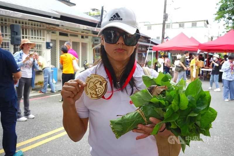 今年の大会で優勝した陳さんのカタツムリと陳さん＝5月25日、張祈撮影