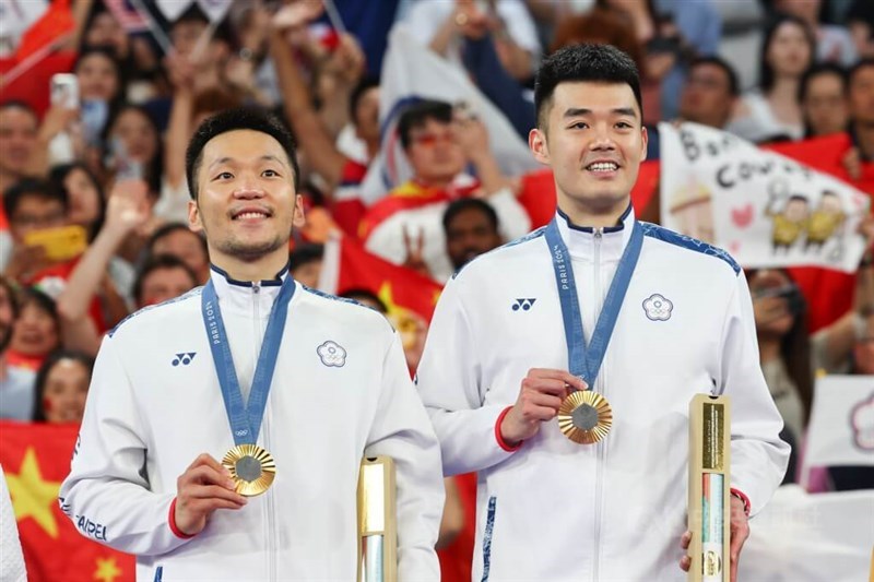 バドミントン男子ダブルスで李洋(左)・王斉麟(右)組が前回東京大会に続いて金メダルを獲得。パリ大会で台湾に最初の金メダルをもたらした。表彰式では金メダルを手に笑顔を見せた=2024年8月5日、中央社撮影