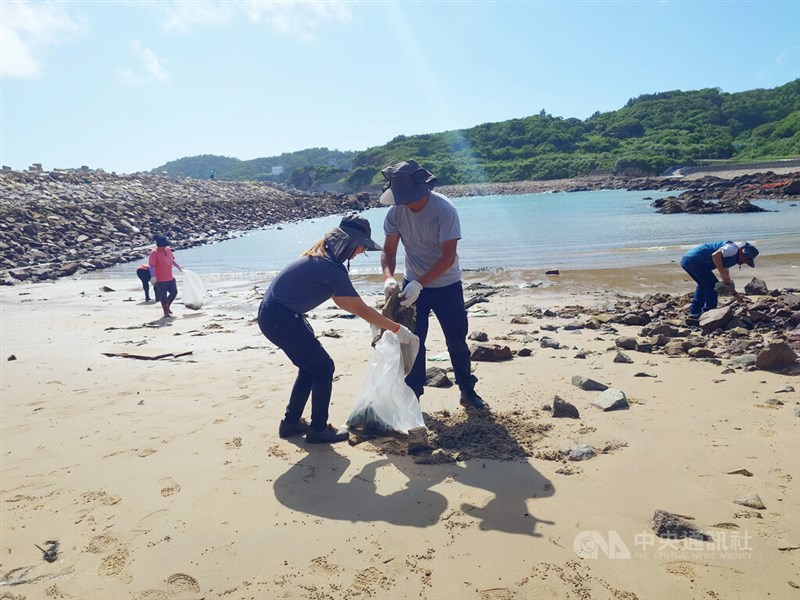 海岸を清掃する人々＝13日、潘欣彤撮影