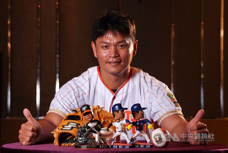 記者会見で今季限りでの引退を表明する潘。ボブルヘッド（首振り）人形＝の発売も発表された＝2024年8月1日、台北市