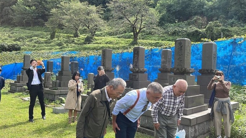 川上善兵衛氏の墓を参拝する（手前左から）樹生酒荘創業者の洪吉倍さん、高雄餐旅大学の陳千浩副教授（陳さん提供）