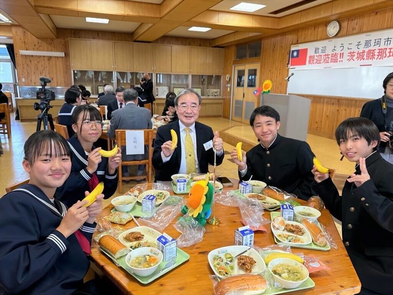 茨城県の那珂市立第一中学校を訪問し、バナナが献立に含まれた給食を生徒らと共に食べ、交流した農業部の胡忠一政務次長（中央）＝農糧署提供