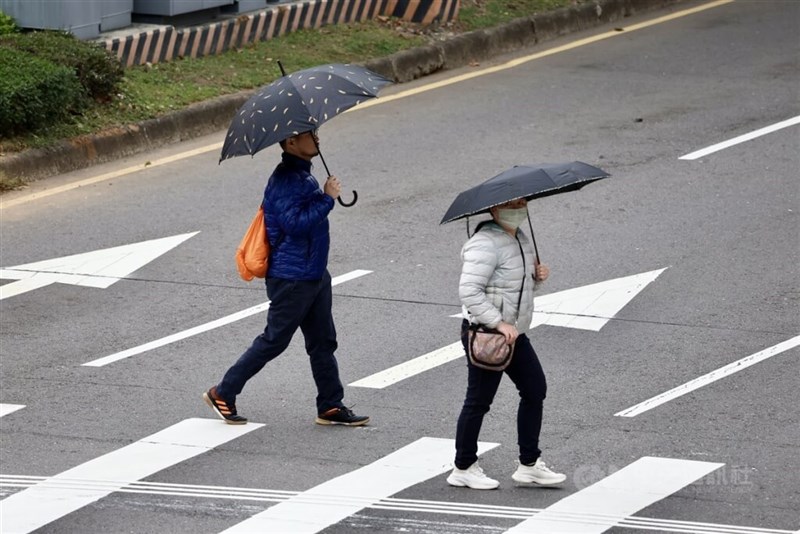 傘を差して横断歩道を渡る歩行者たち＝台北市士林区（資料写真）