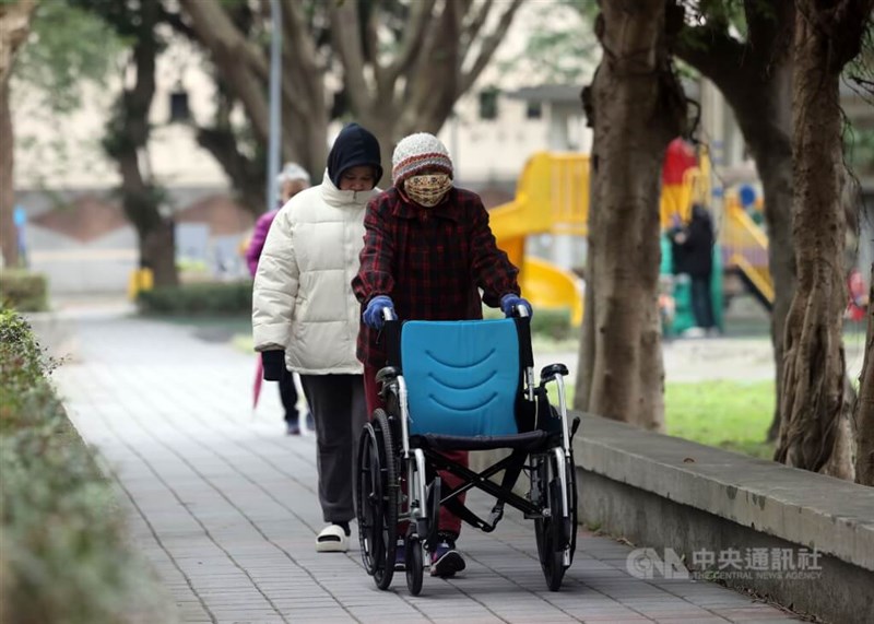 防寒服や帽子などで寒さを防ぐ人たち＝台北市文山区(資料写真)