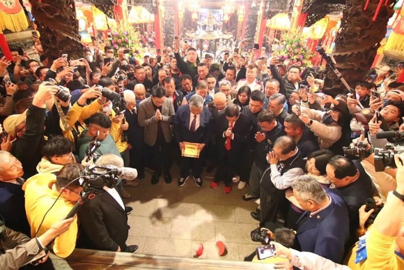 神意を問う道具、赤い三日月型のポエを使って大甲媽祖巡行の日時を確認する鎮瀾宮の役員ら＝鎮瀾宮提供