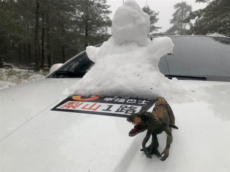 台中市和平区梨山で、乗用車型のバスに載せられた雪製の人形＝台中市政府交通局提供