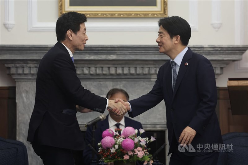 西村康稔元経済産業相（左）と笑顔で握手する頼清徳総統＝5月5日、台北市