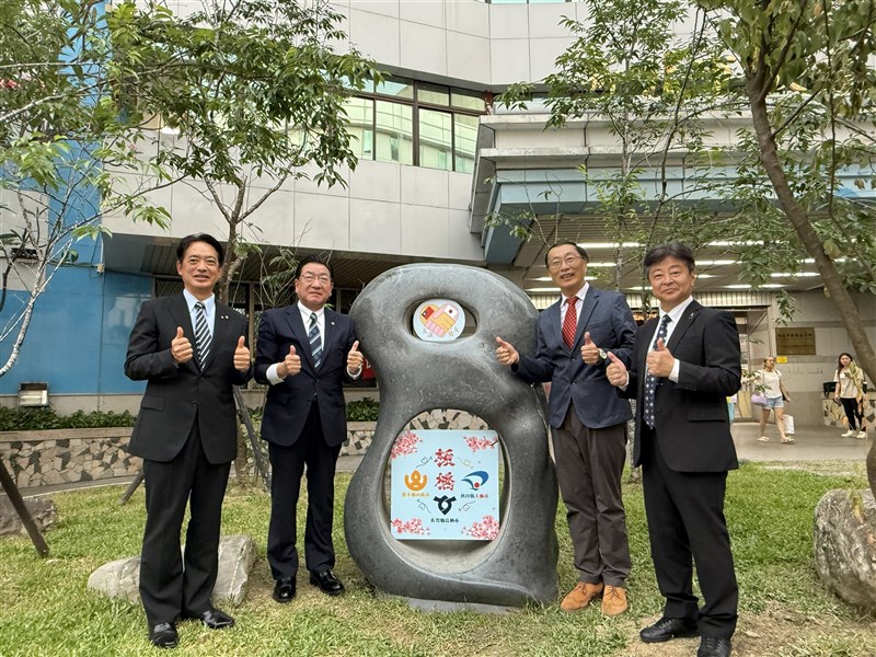 板橋区公所（役所)前に設置された台日の友情記念碑と記念撮影する（左から）佐賀県鳥栖市の向門慶人市長、秋田県大仙市の老松博行市長、陳奇正板橋区長、熊本県山鹿市の早田順一市長＝新北市政府提供