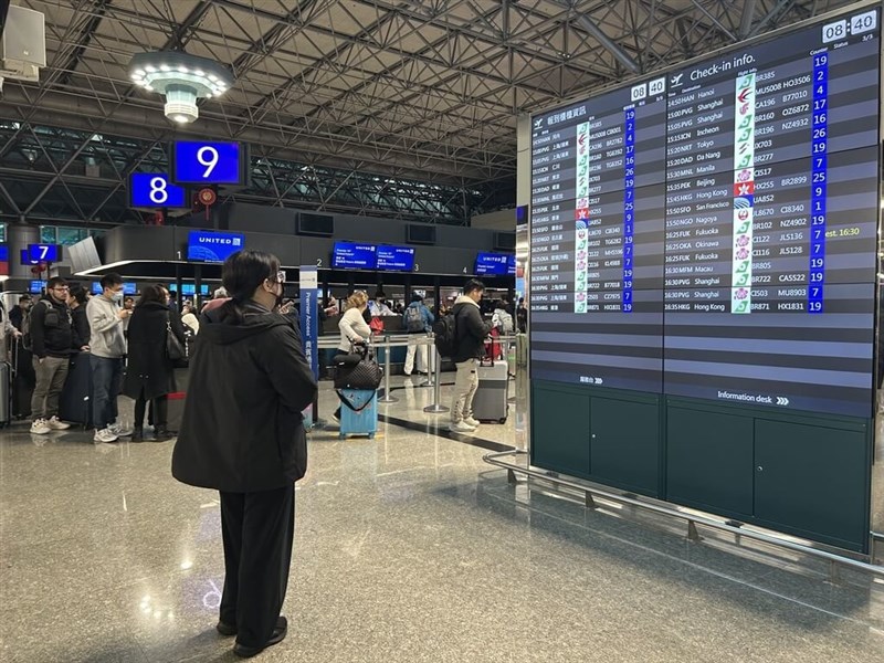 出発ロビーの案内板を見る人＝桃園国際空港提供