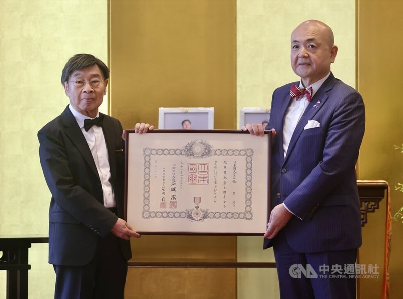 日本台湾交流協会台北事務所の片山和之代表（右）から旭日双光章の勲記を受け取る日本映画評論家の張昌彦さん（左）＝台北で2025年6月16日、中央社記者張皓安撮影