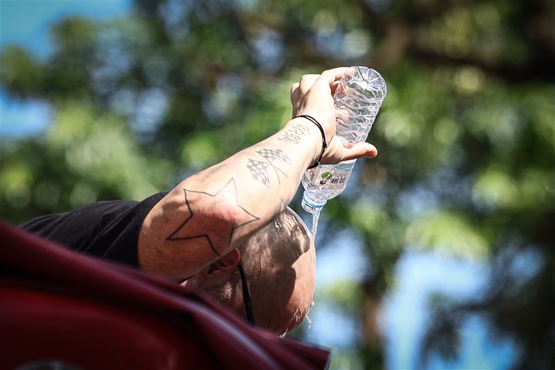 暑さ対策で頭に水をかける男性＝2025年7月1日、中央社記者王騰毅撮影