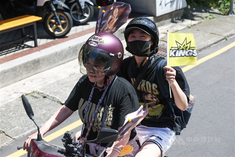 オートバイに乗ってパレードの車列を追いかけるファン＝中央社記者王騰毅撮影