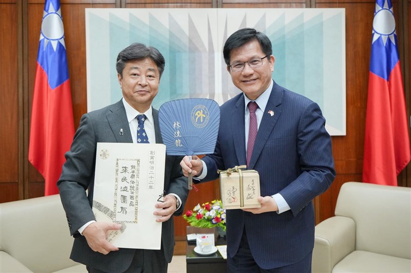 熊本県山鹿市の早田順一市長（左）から同県伝統工芸品のうちわを贈られる外交部の林佳竜部長＝7月2日、台北市（林氏のフェイスブックから）