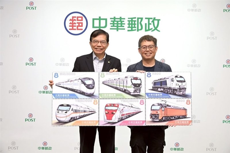 台湾鉄道列車切手第1弾のデザインを手に持つ中華郵政の王国材董事長（左）と切手のイラストを手がける洪致文さん＝7月7日、台北市（同社提供）