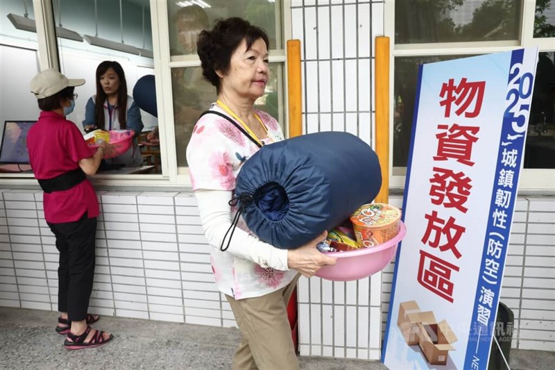 防空演習に合わせて行われた訓練で、生活物資を受け取った市民（右）＝2025年7月17日、中央社記者王騰毅撮影