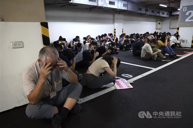 台北市松山区役所の地下駐車場に避難し、頭や耳などを守る市民ら＝2025年7月17日、中央社記者張新偉撮影