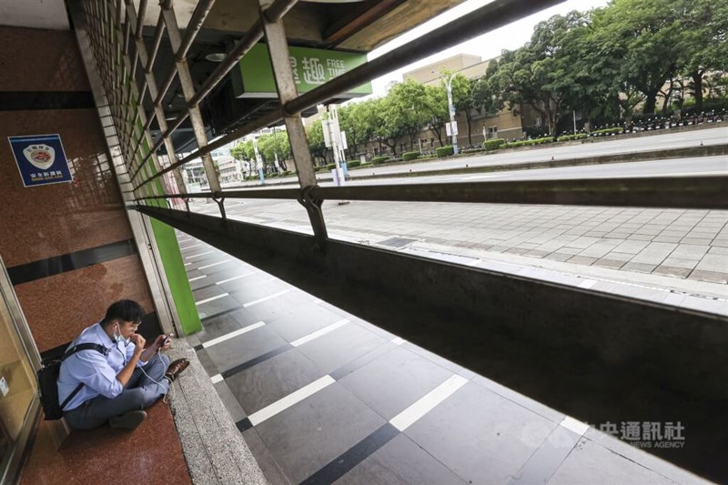 シャッターが下ろされた台北市中正区の建物の敷地内で防空演習の終了を待つ市民＝2025年7月17日、中央社記者鄭清元撮影