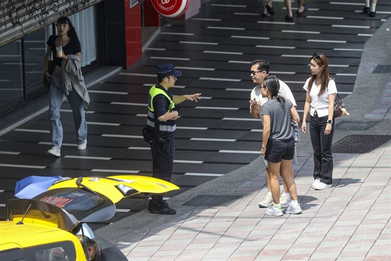 防空演習の直前に、歩行者に注意を呼びかける警察官（右4）＝2025年7月17日、中央社記者鄭清元撮影