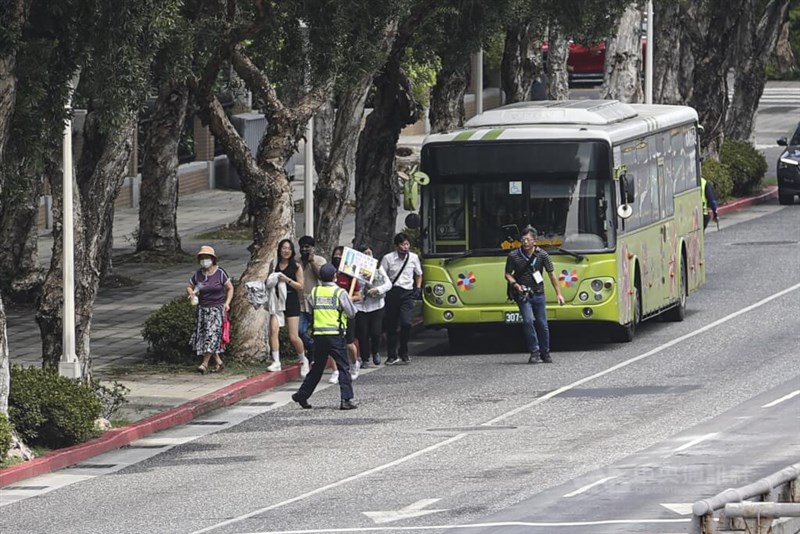 台北市の幹線道路で路肩に停車したバスから降り、避難する乗客ら＝2025年7月17日、中央社記者鄭清元撮影