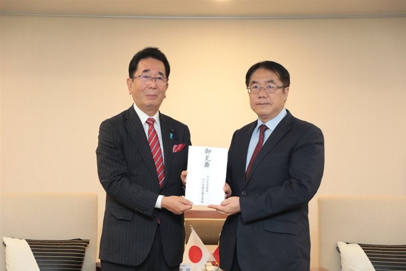 日台友好促進山口県議会議員連盟の島田教明会長（左）から見舞金を受け取る黄偉哲台南市長＝7月23日、台南市（同市政府提供）